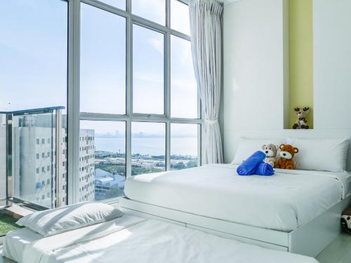a bedroom with two beds and a large window at Penang Straits Garden Condominium Georgetown in George Town