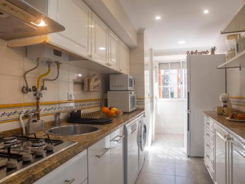 uma cozinha com armários brancos, um lavatório e um frigorífico em Apartment Olivais by Interhome em Lisboa