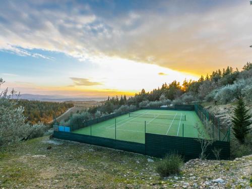 a tennis court on a hill with the sunset in the background at Holiday Home Casa Patrizia by Interhome in Monsanto