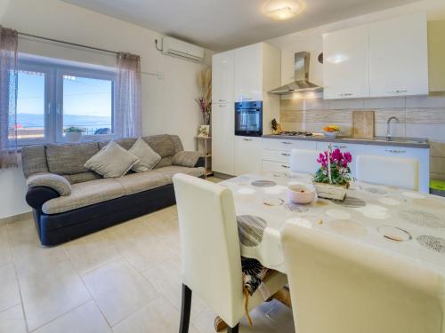 Il comprend une cuisine et un salon avec une table et un canapé. dans l'établissement Apartment Edita by Interhome, à Lovran