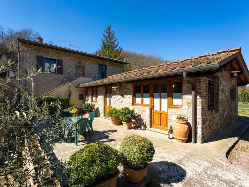 a stone house with a table and chairs in a yard at Holiday Home Casa Mario by Interhome in Greve in Chianti