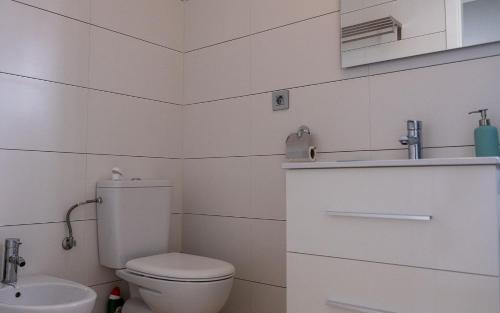 ein weißes Bad mit einem WC und einem Waschbecken in der Unterkunft Pinet beach 86 in Elche
