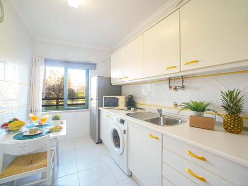 une cuisine blanche avec un évier et un lave-vaisselle dans l'établissement Apartment Garden Place by Interhome, à Armação de Pêra