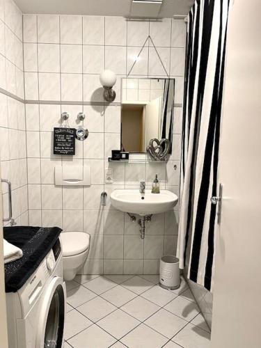 a bathroom with a sink and a washing machine at Dachgeschosswohnung mit 2 Schlafzimmern Zentrum Nord mit Aufzug in Leipzig