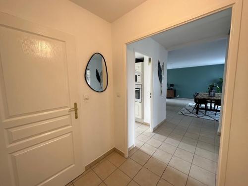 a hallway with a door and a mirror on the wall at L'escale du Trianon in Le Plessis-Robinson