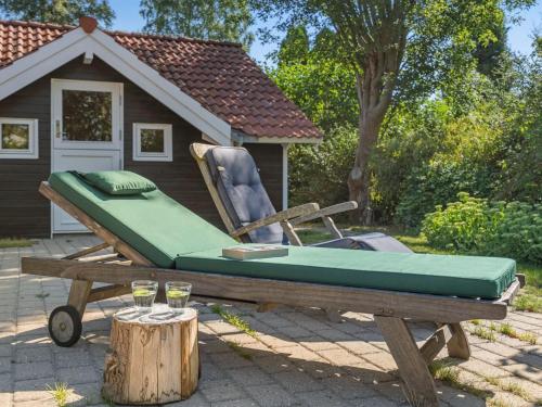 łóżko i krzesło siedzące na stole piknikowym w obiekcie Holiday Home Liselotta - 550m from the sea in Sealand by Interhome w mieście Hornbæk