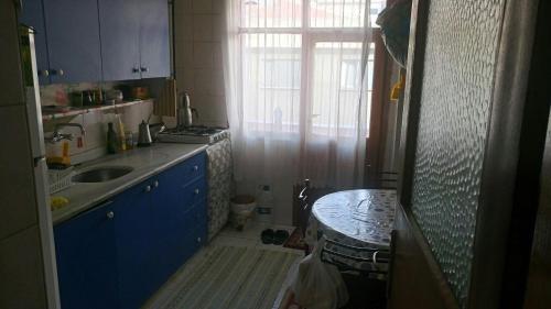 kuchnia z niebieskimi szafkami, zlewem i stołem w obiekcie Private Room in Istanbul #62 w Stambule