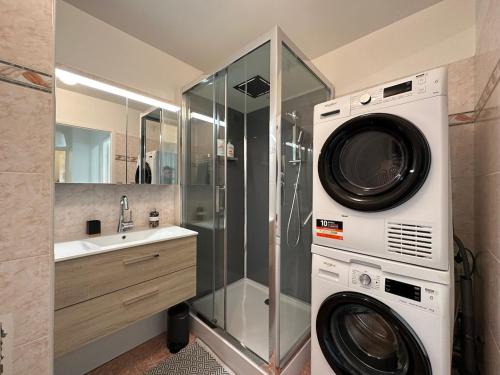a bathroom with a washing machine and a sink at L'escale du Trianon in Le Plessis-Robinson