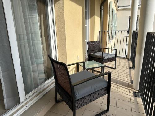 two chairs and a table on a balcony at L'escale du Trianon in Le Plessis-Robinson