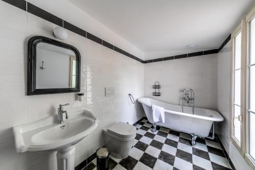 a bathroom with a sink and a tub and a toilet at Le Garage, Le Gite in Fontevraud-l'Abbaye