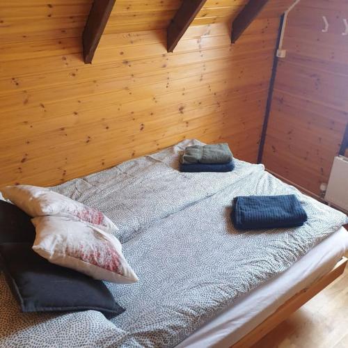 a bed with two pillows on it in a room at Árheimar 4 cosy holiday home in Arabaer