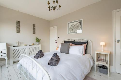 a bedroom with a white bed with shoes on it at The House in Deal in Deal