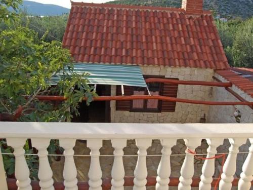 a white railing in front of a house with a roof at Apartments Mirko in Seget Vranjica