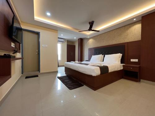 a bedroom with a large bed and a flat screen tv at The Rhino in Guwahati