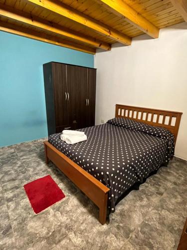 a bedroom with a bed and a wooden cabinet at Araucarias Apart in Esquel