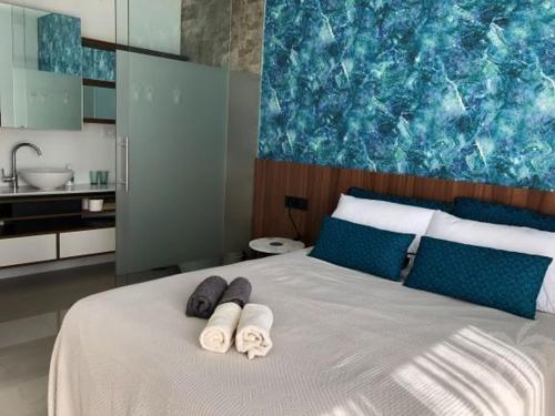 Un dormitorio con una cama con toallas. en Beach Avenue Residence, en Arenales del Sol
