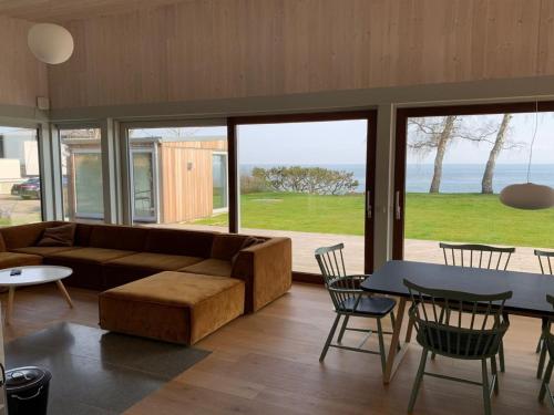 een woonkamer met een bank en een tafel en stoelen bij Holiday Home Vanta - 10m from the sea in Sealand by Interhome in Gilleleje