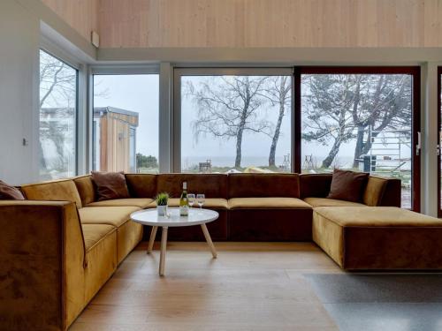 een woonkamer met een bruine bank en een tafel bij Holiday Home Vanta - 10m from the sea in Sealand by Interhome in Gilleleje