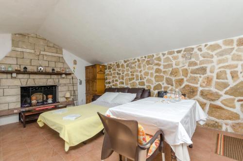 a bedroom with two tables and a stone wall at House Lucica in Splitska