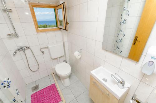 a bathroom with a toilet and a shower and a sink at House Lucica in Splitska