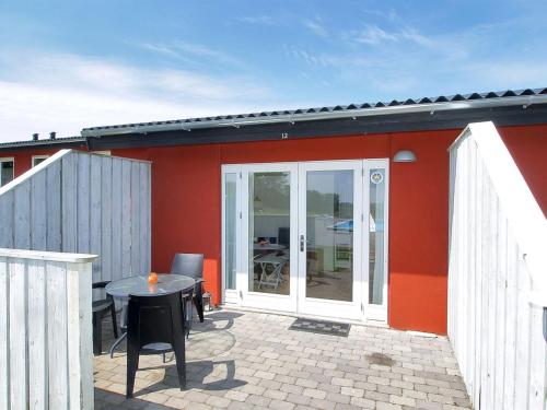 Åkirkeby的住宿－Apartment Valio - 6km from the sea in Bornholm by Interhome，红色的房子,设有配有桌子的庭院