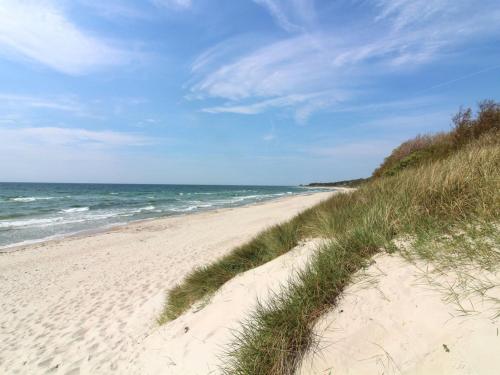 a sandy beach with the ocean in the background at Holiday Home Gerty - 300m from the sea in Bornholm by Interhome in Vester Sømarken