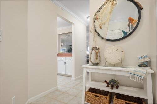 a white hallway with a mirror and a shelf at Sea Place 11211 in Butler Beach