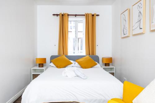 a bedroom with a white bed with yellow accents at Delightful city centre apartment with balcony in Dublin