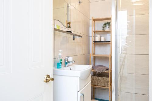 a white bathroom with a sink and a shower at Delightful city centre apartment with balcony in Dublin