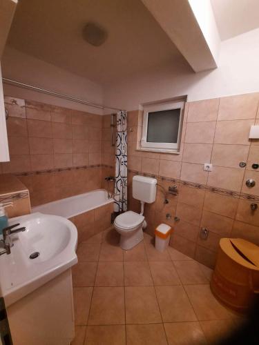 a bathroom with a toilet and a tub and a sink at Marko in Podstrana