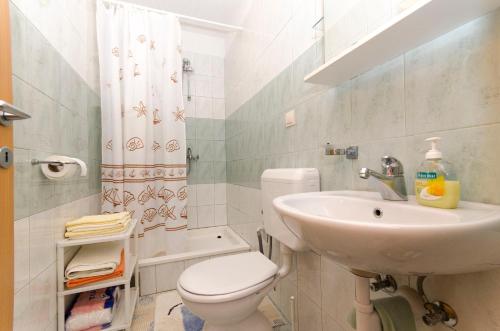 a bathroom with a toilet and a sink at House Petric in Bol