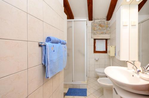 a white bathroom with a sink and a toilet at Apartment Josip in Plomin