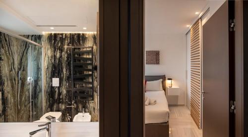 a bedroom with a bed and a bathroom with a window at GENTILE 46 LUXURY ACCOMODATION in Bari