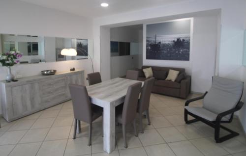 een keuken en een woonkamer met een tafel en stoelen bij I Giganti in Cagliari
