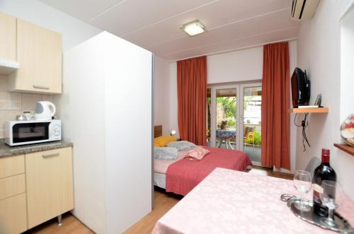 a small room with a bed and a kitchen at Apartments Maja in Štinjan