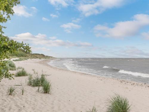 a sandy beach with the ocean in the background at Holiday Home Henrich - 300m from the sea in Bornholm in Vester Sømarken