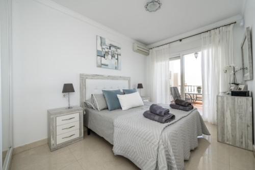 een slaapkamer met een bed met blauwe kussens erop bij Mirador De Mijas Luxury Apt Blq 6 Mijas in Mijas