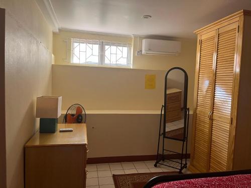 Cette chambre comprend un bureau, une fenêtre et une chaise. dans l'établissement TETE Comforts, à Roseau