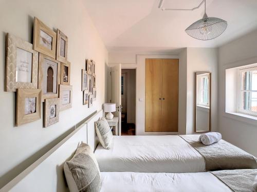 a bedroom with two beds and pictures on the wall at FX City Lover by LovelyStay in Funchal