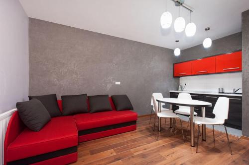 ein Wohnzimmer mit einem roten Sofa und einem Tisch in der Unterkunft Apartament Mysia in Świeradów-Zdrój