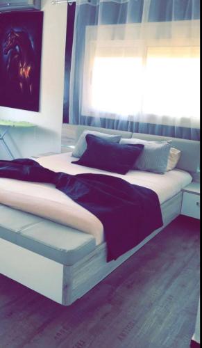 - une chambre dotée d'un lit blanc avec des draps et des oreillers violets dans l'établissement SO CHIC APPARTEMENT Airport international Rabat-Salé, à Sale