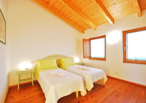 a bedroom with two beds and two windows at Corte all'Olmo in Ca' di David
