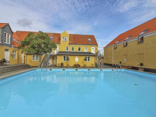 グドイェムにあるApartment Thyrne - 500m from the sea in Bornholm by Interhomeの一部の建物の前に大きなスイミングプールがあります。