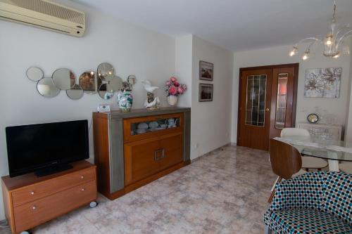 sala de estar con TV de pantalla plana y mesa en La Mirada 2, en Castellón de la Plana