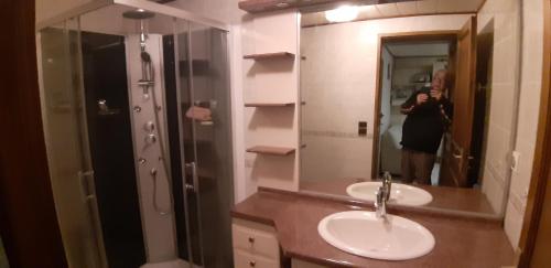 a woman taking a picture of a bathroom with two sinks at studio pres du lac d'annecy in Seythenex