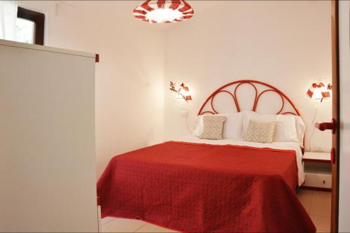 a bedroom with a bed with a red bedspread at CASE BELVEDERE in Chia