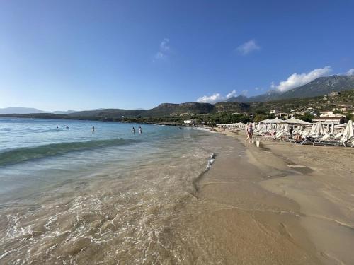 a beach with a group of people in the water at Rapunzel's Tower Mani in Neokhórion
