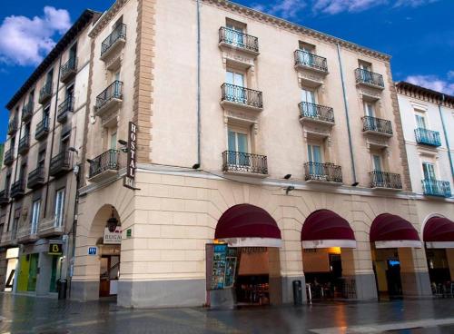 un gran edificio con balcones en un lateral en Hostal Rugaca en Huesca