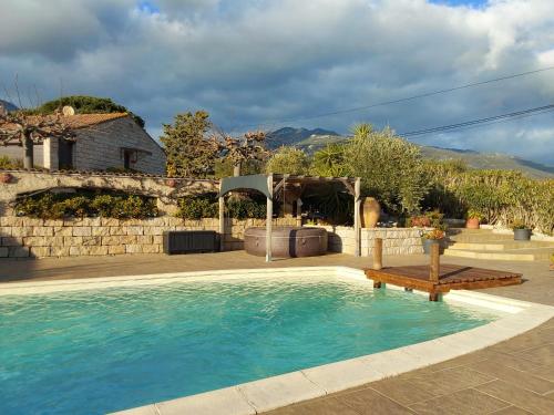 - une piscine dans une cour dotée d'un mur en pierre dans l'établissement Magnifique villa piscine Propriano, à Olmeto