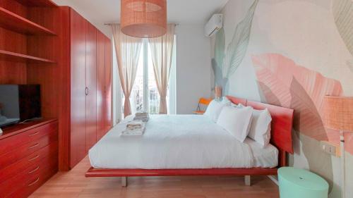 a bedroom with a white bed with red furniture and a tv at Italianway - Brianza 14 A in Milan
